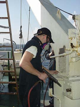 stick em up: 3/c Zack Leo uses his needle gun to bust rust on one of the davits.