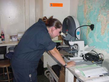 microscope: 4/c Jessica Lewis (Farmington NH)examines the critters hidden in a drop of sea water.