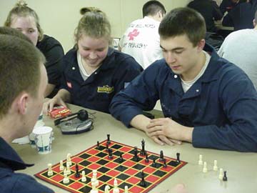 checkers: cadets amuse themselves in the mess deck after dinner.