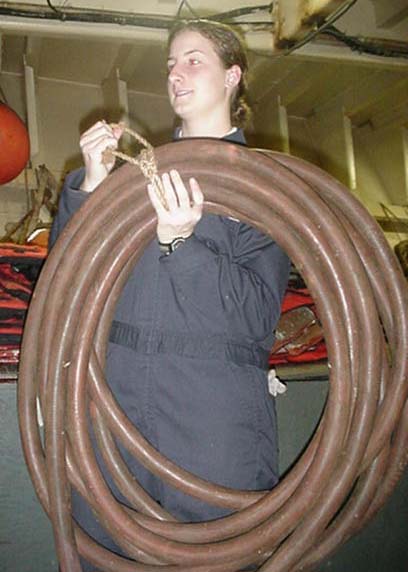 hoses: a cadet carries the pneumatic hose for the needle gun- used to bust rust