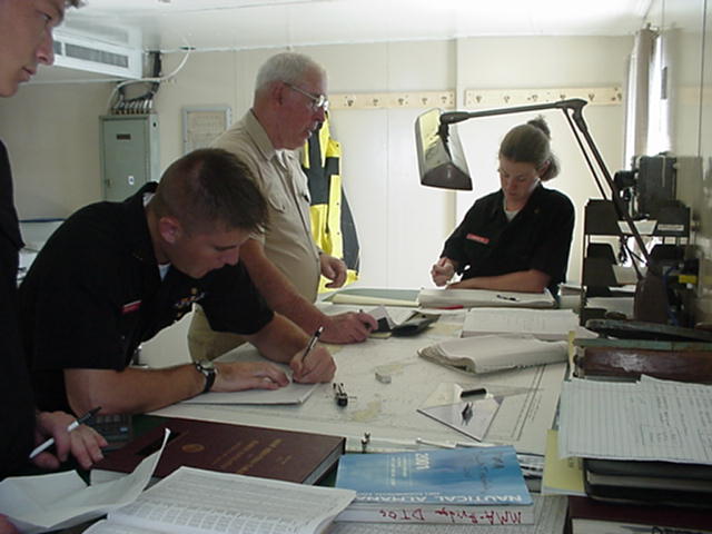 Nav1.jpg: In the aft chartroom, Capt Bob Buckley (MMA'62) instructs 1/c Eunice Cadorette and 1/c Joe Reisinger in plotting techniques.
